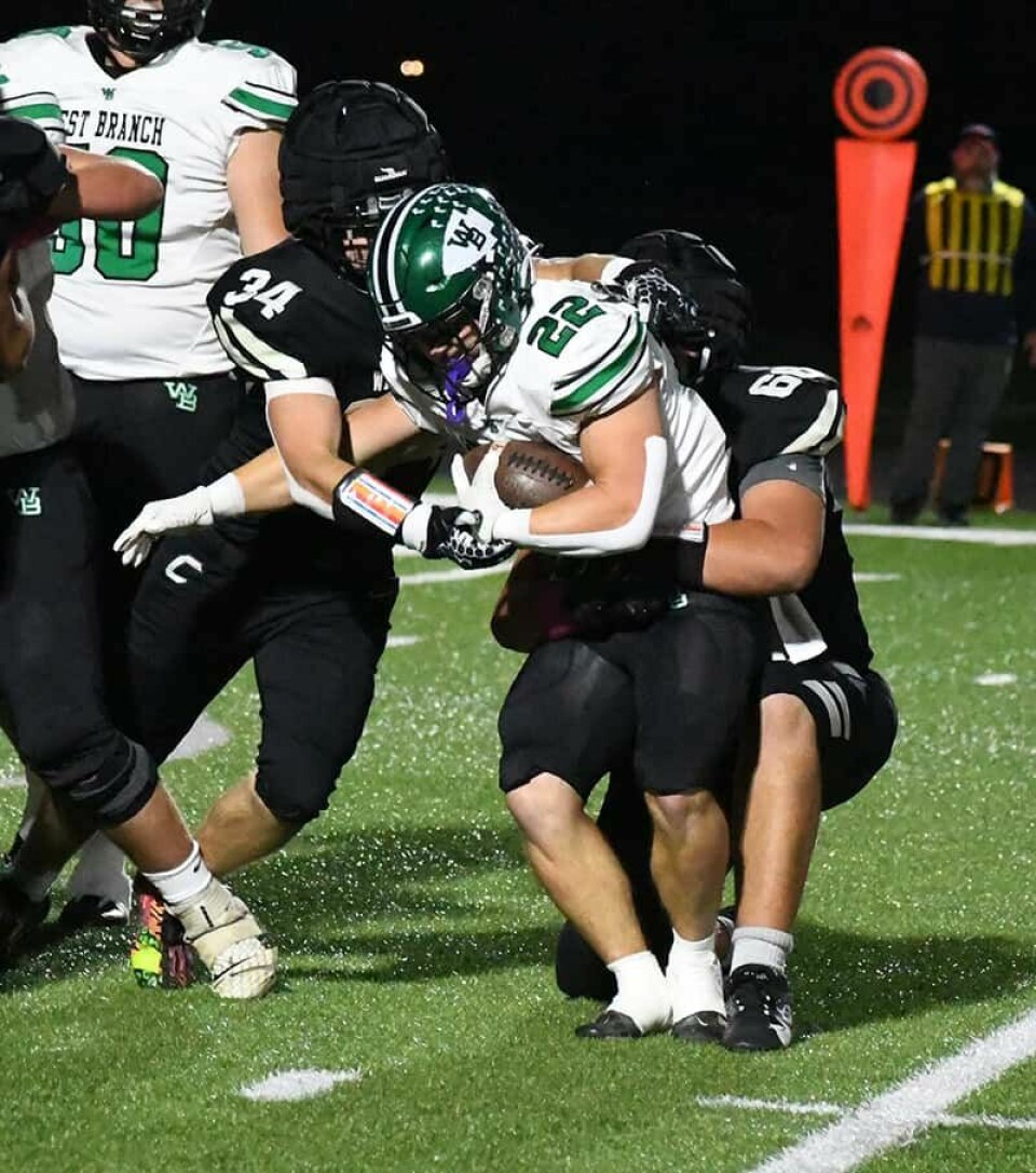 CCM/Dan RiesCarrollton defenders Levi Crider (34) and Tucker Burgett (66) bring down West Branch running back Boston Mulinix (22) for a loss Friday at Community Field.
