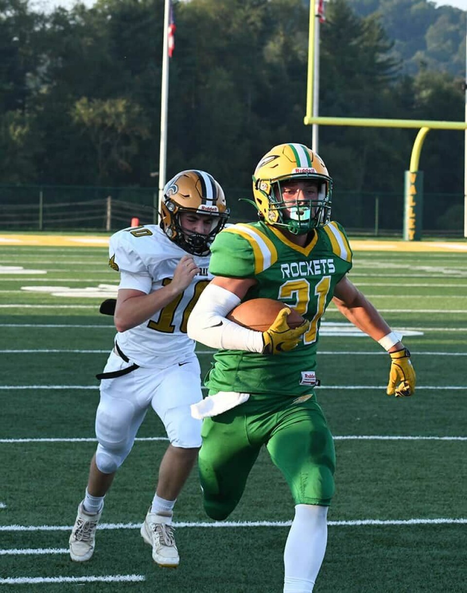 CCM/Pete McIntireBrooks Bower (21) races down the sideline on his way to a 59-yard touchdown in the first half of Saturday’s game against Tuscarawas Central Catholic. TCC freshman Flynn Renicker is in pursuit.