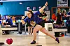 Young bowler in motion at a bowling alley.