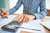 Person using a calculator with financial documents on a desk.