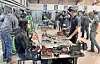 Students working on welding projects in a workshop.