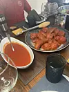 Platter of meatballs and sauce on a dining table.