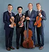 String quartet members with their instruments in a studio setting.