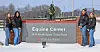 Students in winter attire stand by the Equine Center sign.