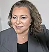 Woman in a gray blazer smiling at the camera.