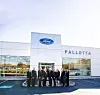 Group of professionals in suits outside Pallotta Ford dealership.