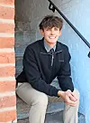 Young man sitting on stairs, smiling.