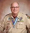 Scout leader in uniform with badges and a medal.