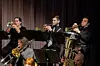 Musicians playing trumpets on stage.