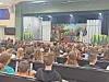 Students watching a live performance in a school auditorium.