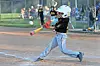 Youth baseball player swinging a bat in a game.
