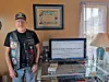 Veteran in a home office with a computer and military patches.
