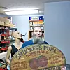 Man holding a Smucker's sign in a workshop.