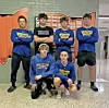 Wrestling team members in blue and black clothing pose together.