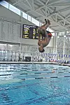 Diver flipping above the pool at a competition.