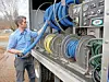 Technician managing hoses from a service truck.