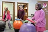 Three people using exercise balls in a fitness activity.