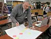 Participant writing on a large sheet of paper in a workshop.