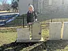 Visitor with flowers at a gravestone in a cemetery.
