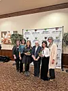 Group of women posing with awards at a community event.