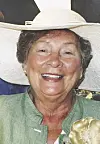 Smiling woman in a white hat and green jacket