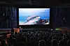 Audience seated in a theater watching a marine life film.