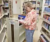 A woman organizes books in a library.