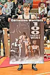 Wrestler holding a poster for 100 varsity wins.