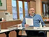 Man reviewing documents at a meeting table.
