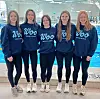 Group of five girls in matching sweatshirts at a swimming pool.
