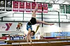 Gymnast in a handstand on the balance beam.
