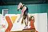 Gymnast in mid-air above the balance beam.