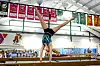 Gymnast in handstand on balance beam