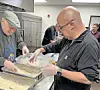 Volunteers preparing food in a kitchen.