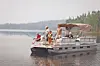 People fishing from a pontoon boat on a lake.
