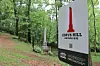 Sign for Copus Hill historic site with a monument in the background.