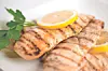 Grilled chicken fillets with lemon slices.
