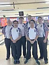 Bowling team in uniforms poses together.