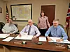 Local government officials seated at a table during a meeting.