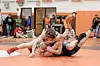 Wrestlers grappling on a mat during a tournament.