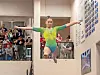 Gymnast in mid-air leap during competition.