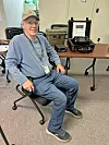 Man sitting in a classroom with communication equipment.