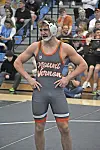 Mount Vernon wrestler in gray uniform stands on the mat.