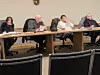 Board members seated at a table during a meeting.
