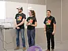 Three students presenting in a classroom.