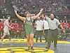 Wrestler in green celebrates victory with referee.