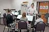 Students in a music lesson with an instructor.