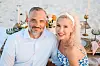 Couple posing at a beach dinner table.