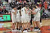 Basketball team huddled together on the court.