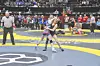 Two female wrestlers grappling on a mat at a championship event.